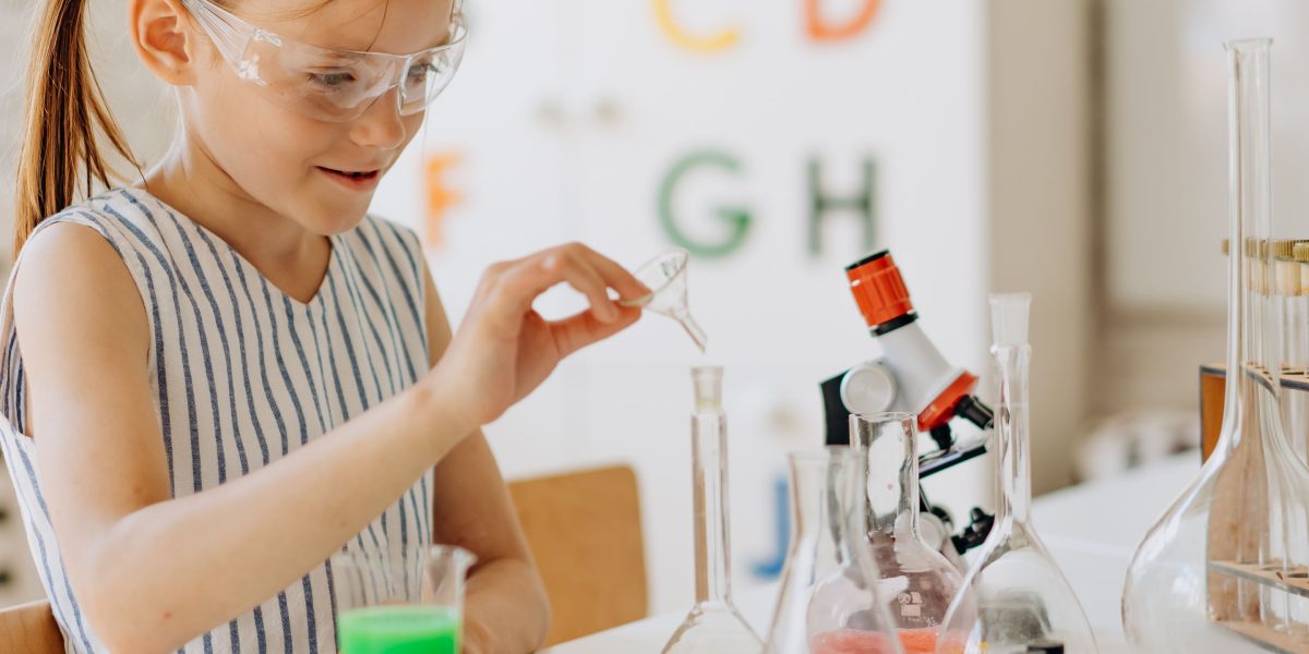 A young student intently focused on their science project, surrounded by materials.