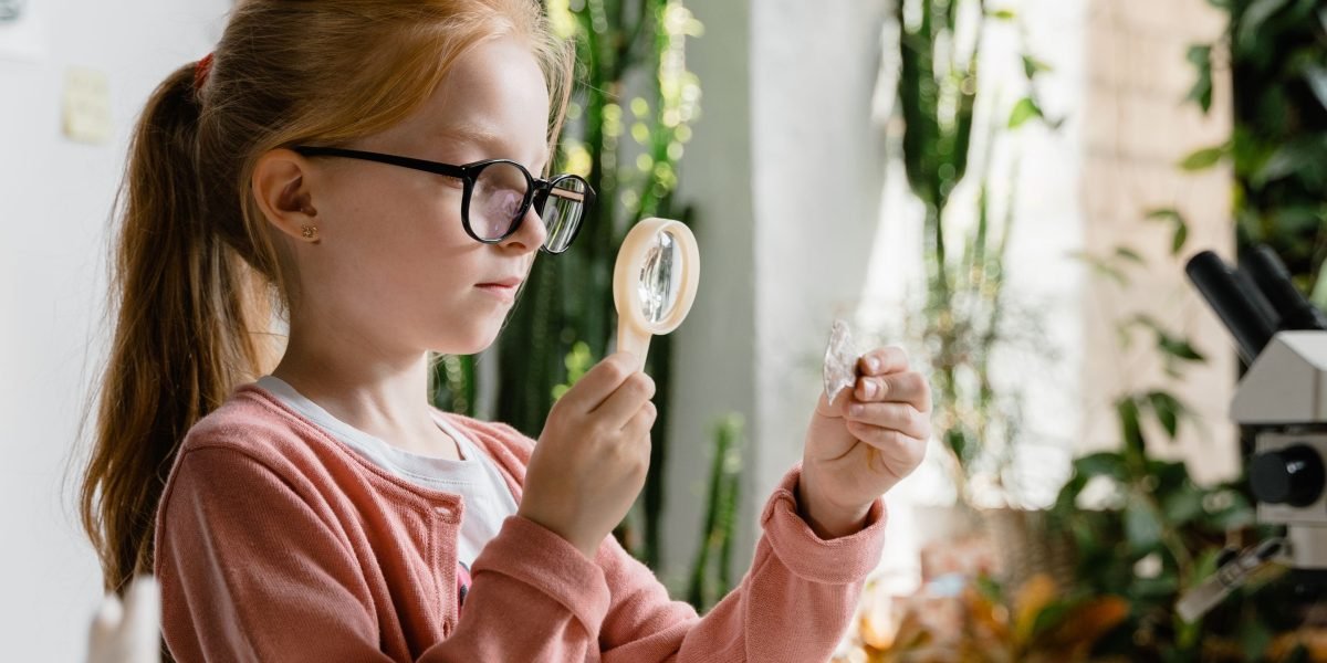 A young student looking thoughtfully at materials, engaging in a moment of discovery and inquiry.