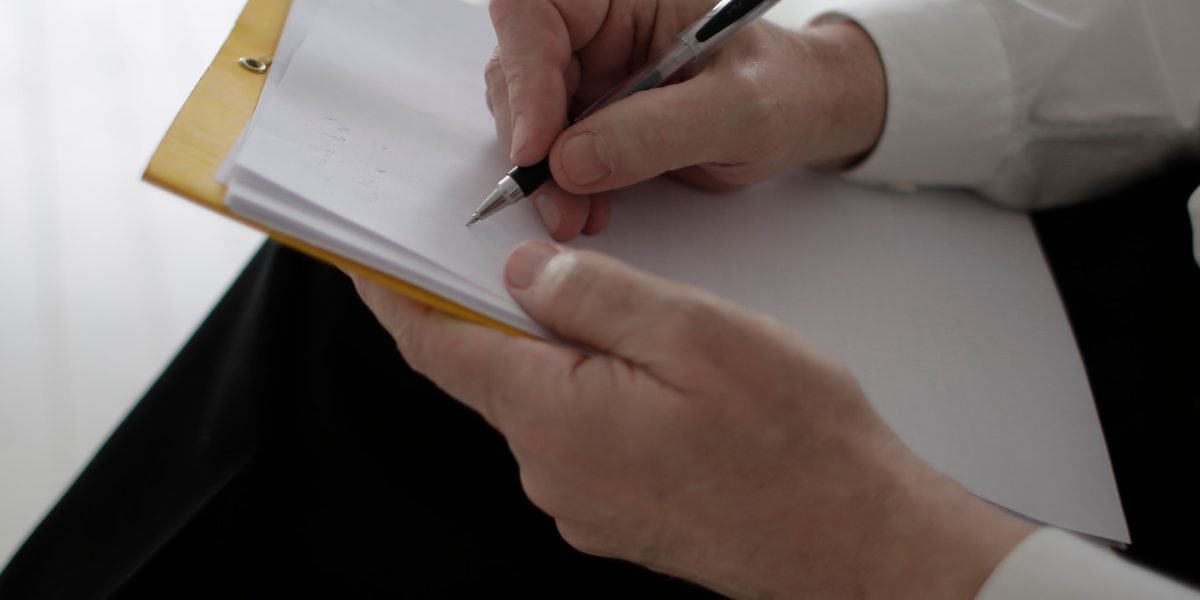 A professional actively taking notes in a meeting or during a lecture, symbolizing the integration of new learning strategies into daily routines.